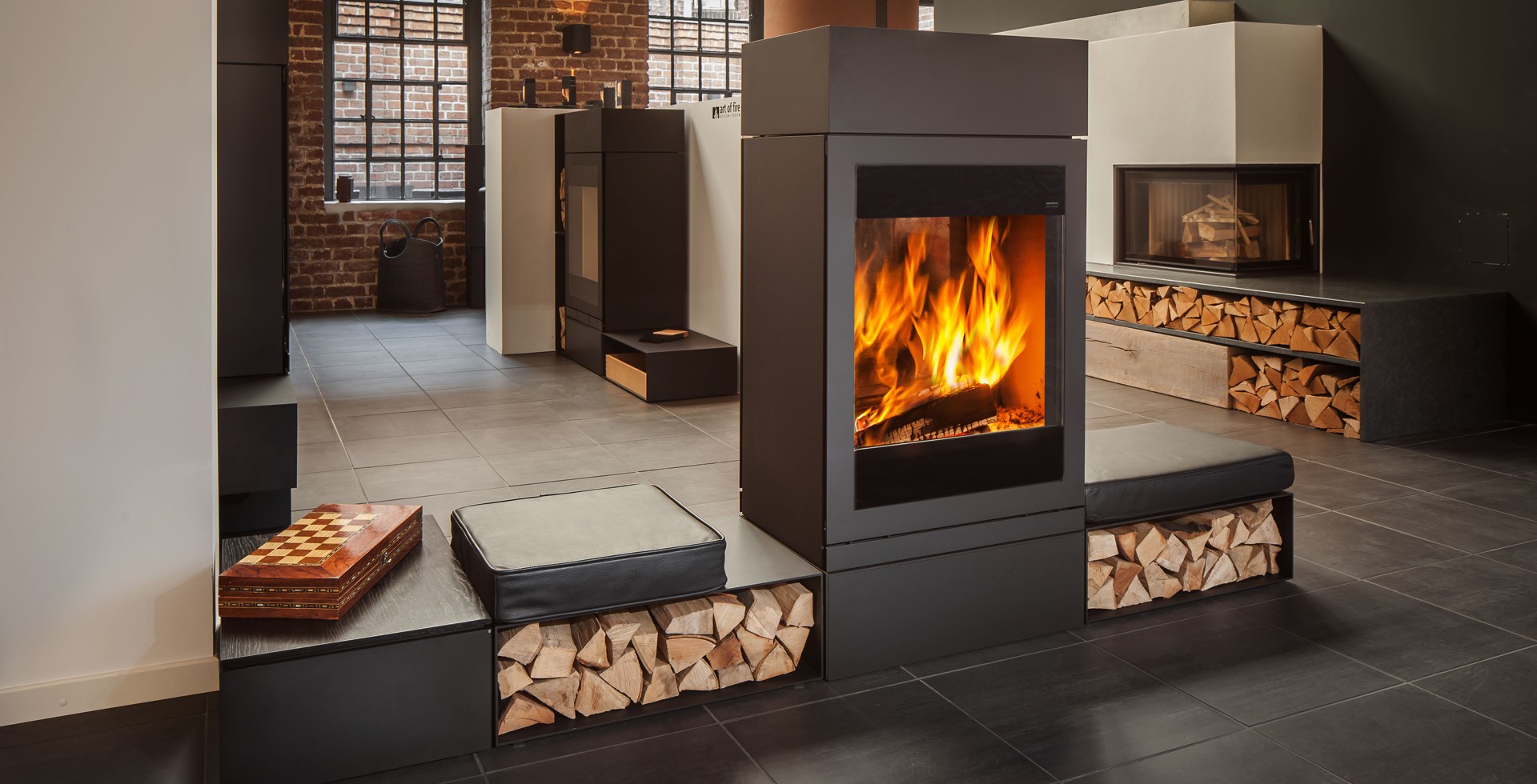 Zu sehen ist ein modern eingerichtetes Wohnzimmer mit Kamin und Sitzflächen und einem Schachbrett.